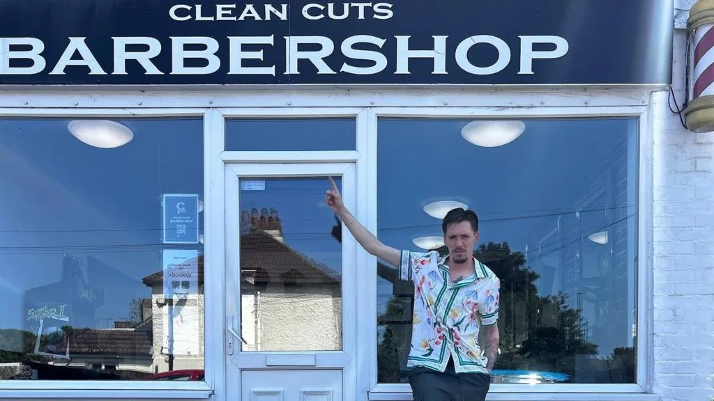 Children receiving free haircuts and school supplies at a Guildford barber shop