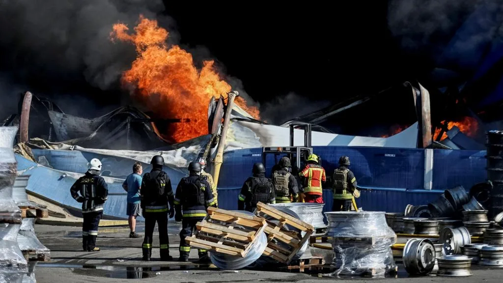 Emergency crews near a damaged weapons depot outside Kyiv after a Russian drone strike