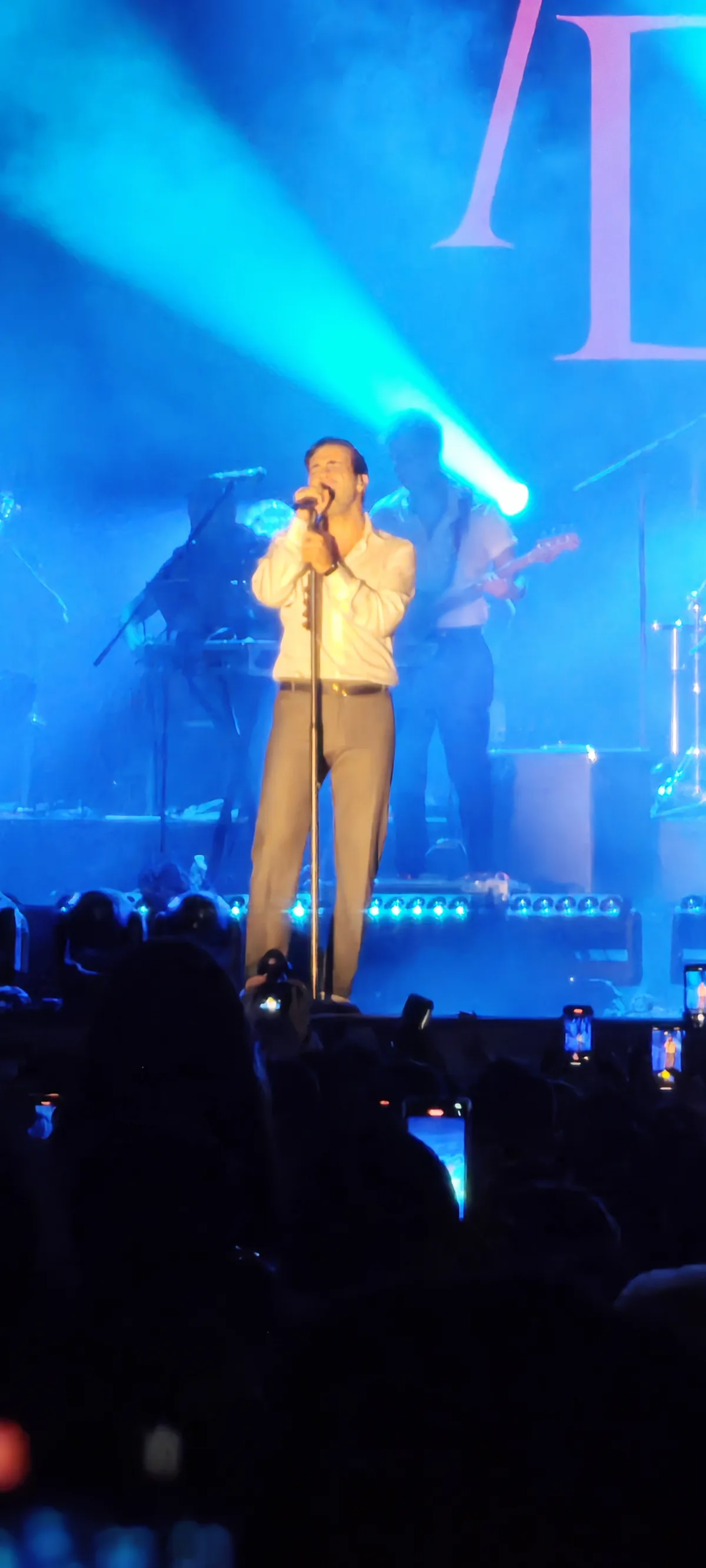Mert Demir'in sahnede mikrofonla performans sergilediği bir konser anı