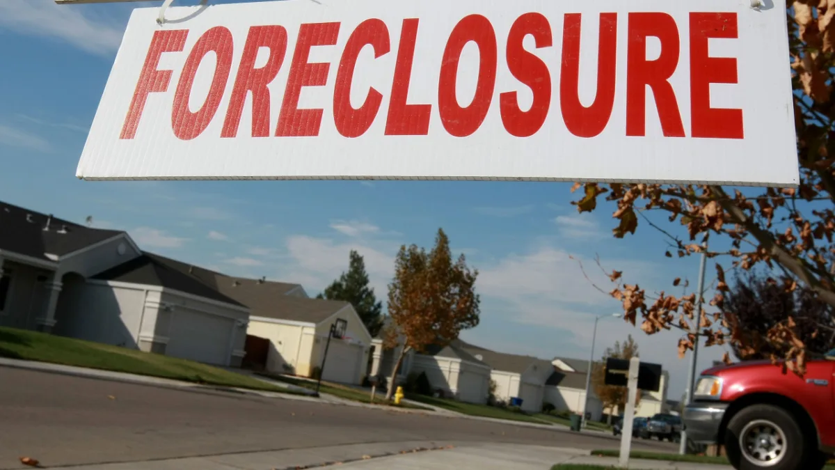 Family reviewing finances over unpaid HOA fees and foreclosure risk in Michigan