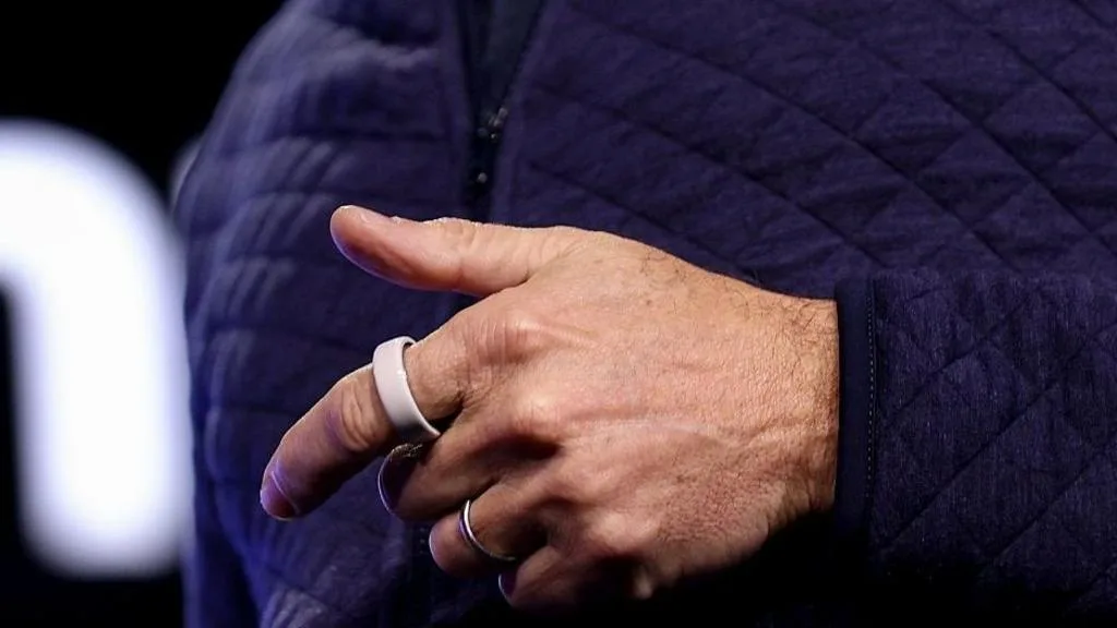 Anillo inteligente de Oura sobre fondo de mercado bursátil