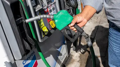 Barriles de diésel y bandera del G7 con gráficos de precios energéticos
